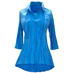 The blouse is shown in color Ocean which can be described as a rich deep blue with violet hues.  The style is a classic collar, flair arms and a tunic length which is longer in the back. The buttons are of the same Ocean color.